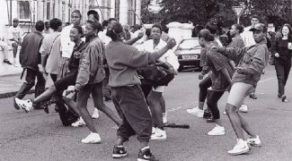Young people dancing in the street to music.